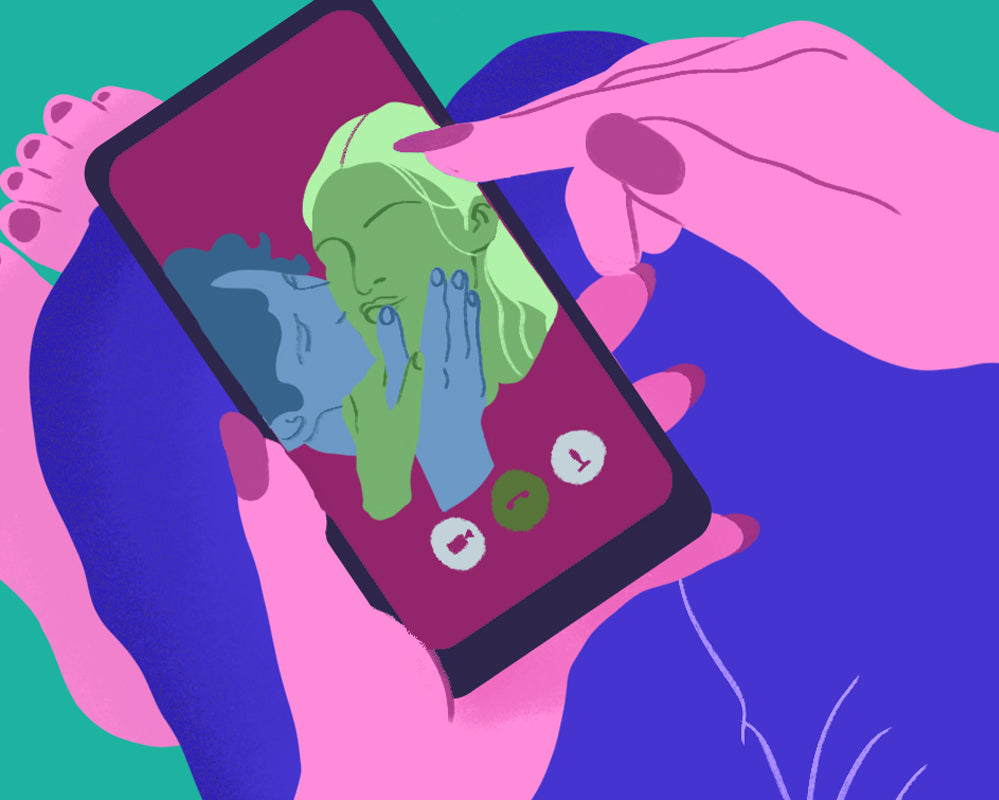 Conto Erótico - Marmita de Casal. Mulher segurando um celular em video chamada com a imagem de um casal heterossexual se beijando.